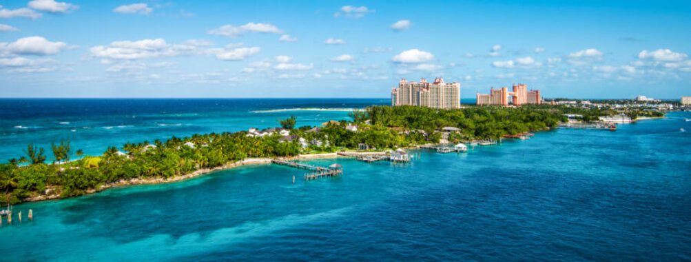 Panoramic view of Paradise Island in Nassau, Bahamas, showcasing lush greenery and turquoise waters under a clear sky.