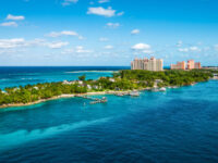 Panoramic view of Paradise Island in Nassau, Bahamas, showcasing lush greenery and turquoise waters under a clear sky.