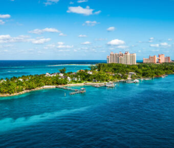 Panoramic view of Paradise Island in Nassau, Bahamas, showcasing lush greenery and turquoise waters under a clear sky.