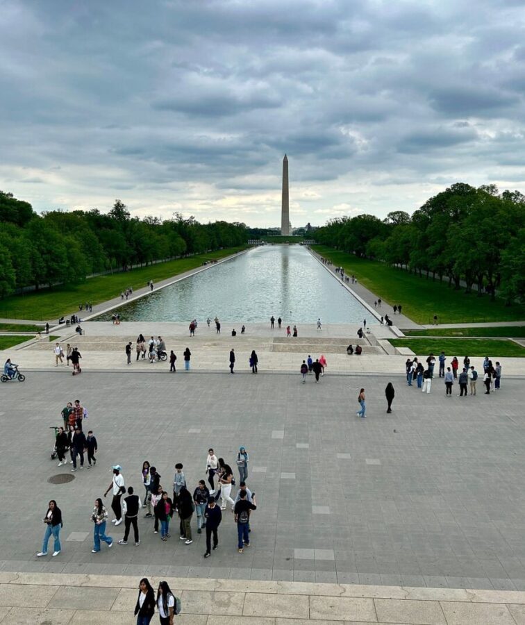 Visitors strolling around the expansive National Mall in Washington, DC, enjoying the sights and atmosphere of the area.
