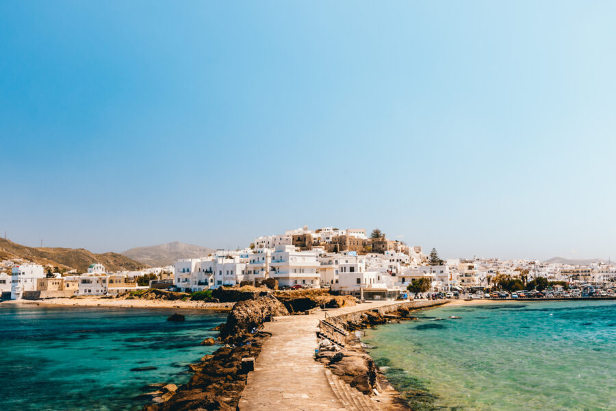 Bright cityscape of Naxos town under clear skies, featuring traditional architecture and vibrant colors in Greece.