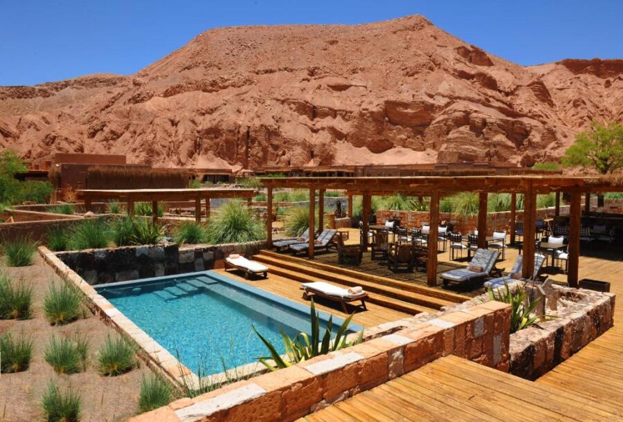 The inviting pool and wooden deck overlook majestic mountains at Nayara Alto Atacama, San Pedro de Atacama, Chile.
