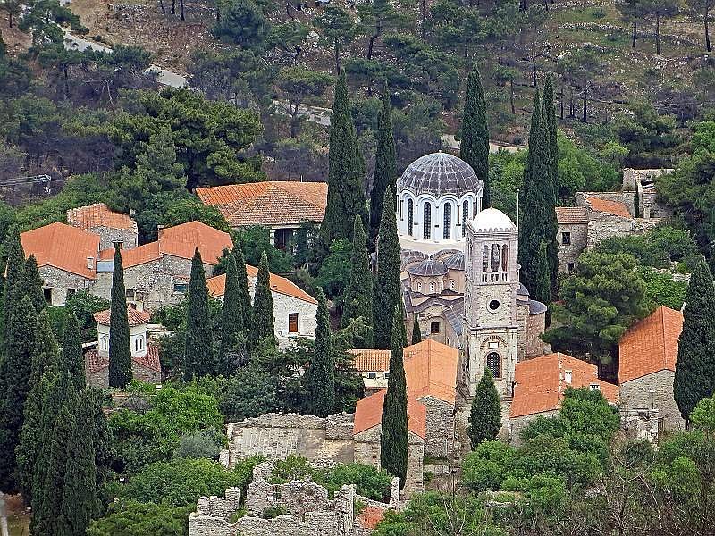 Aerial view of Nea Moni Monastery in Chios, showcasing a village with a prominent church atop a hill.