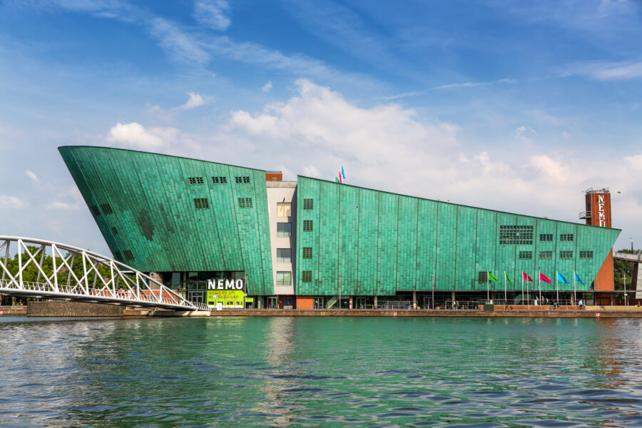 Exterior view of the Nemo Science Museum in Amsterdam, showcasing its distinctive green, ship-like architecture.
