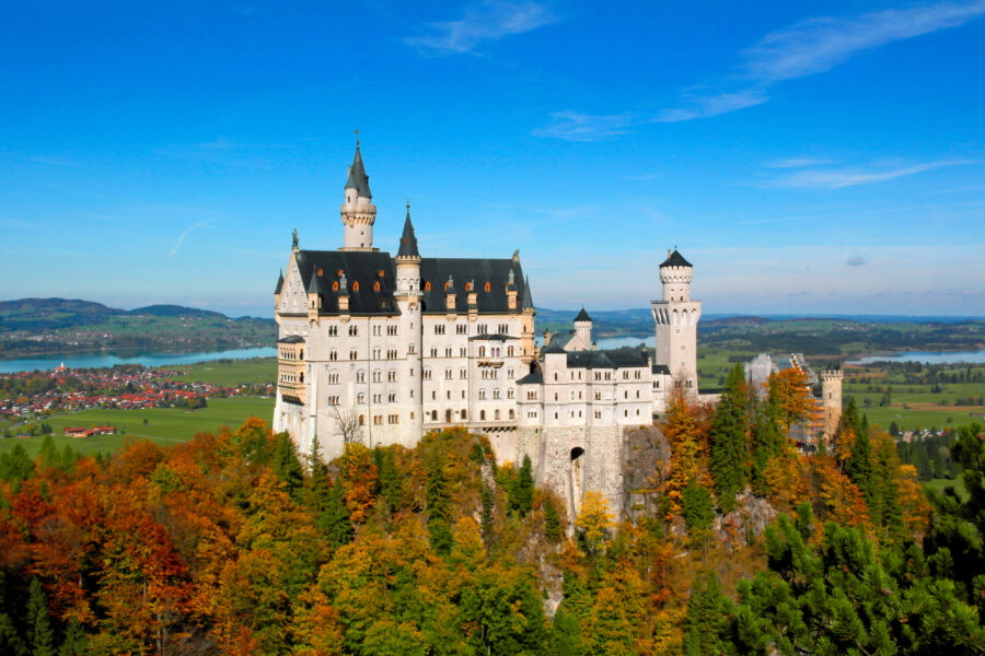 Autumn view of Neuschwanstein Castle surrounded by colorful fall foliage in Bavaria, Germany