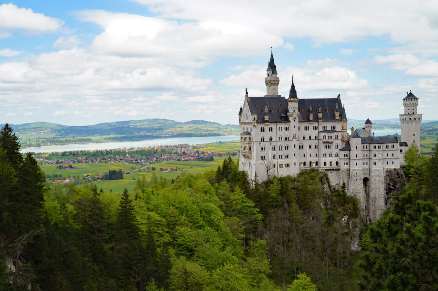 Aerial view of Neuschwanstein Castle on a hill in the Bavarian Alps, above Hohenschwangau village near Füssen