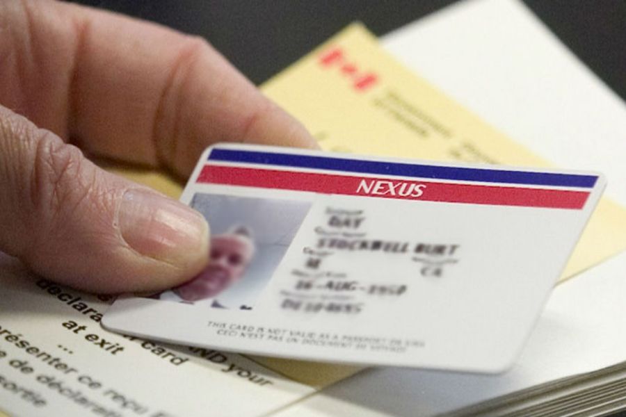 Nexus card held at border crossing between U.S. and Canada, displaying travel details.