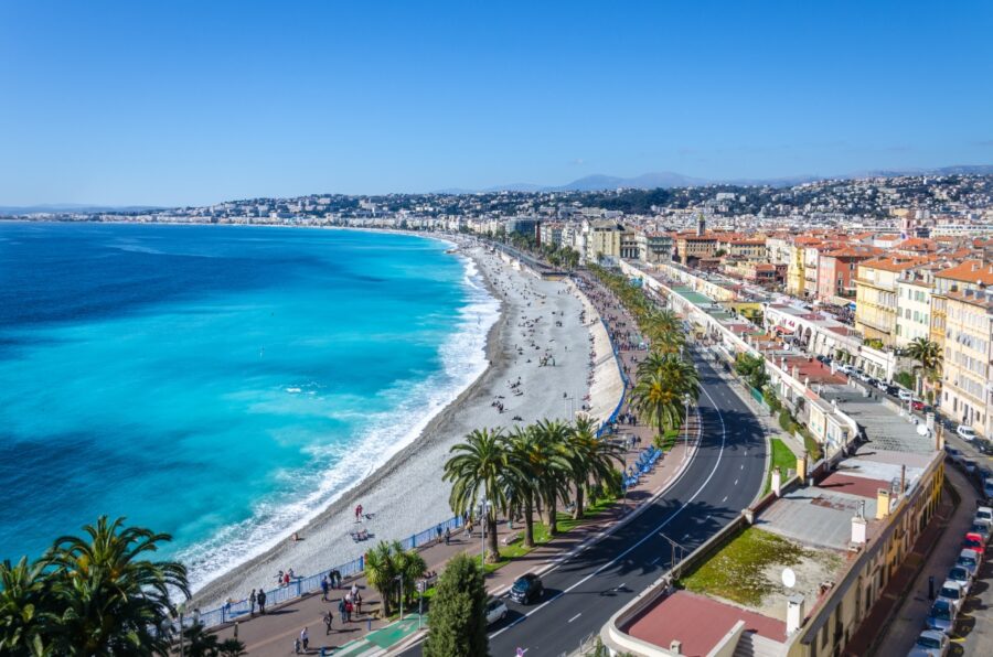 Panoramic view of Nice, showcasing the city, mountains, and the azure sea under a clear blue sky