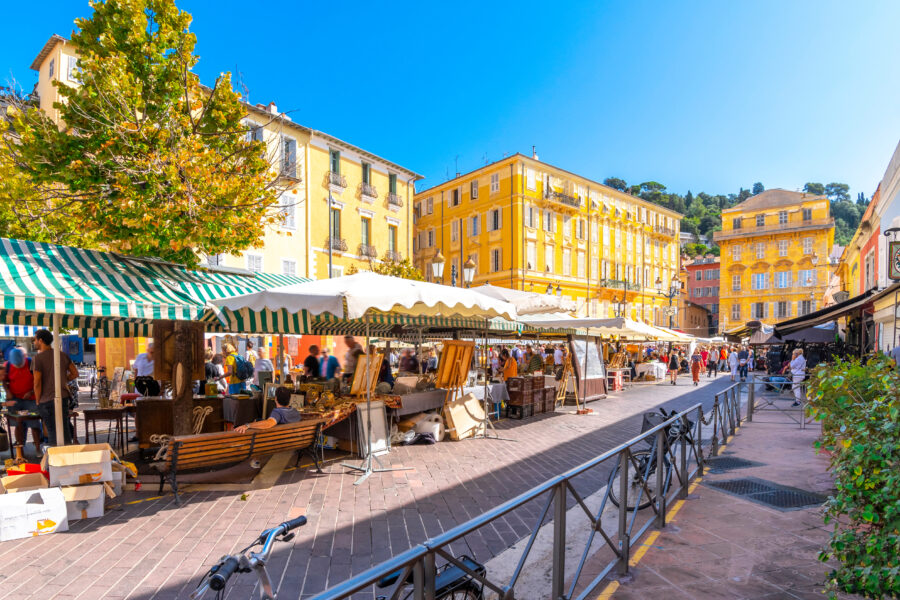 Outdoor Cours Saleya market in Vieux Nice, filled with colorful goods and lively crowds on a bright summer day