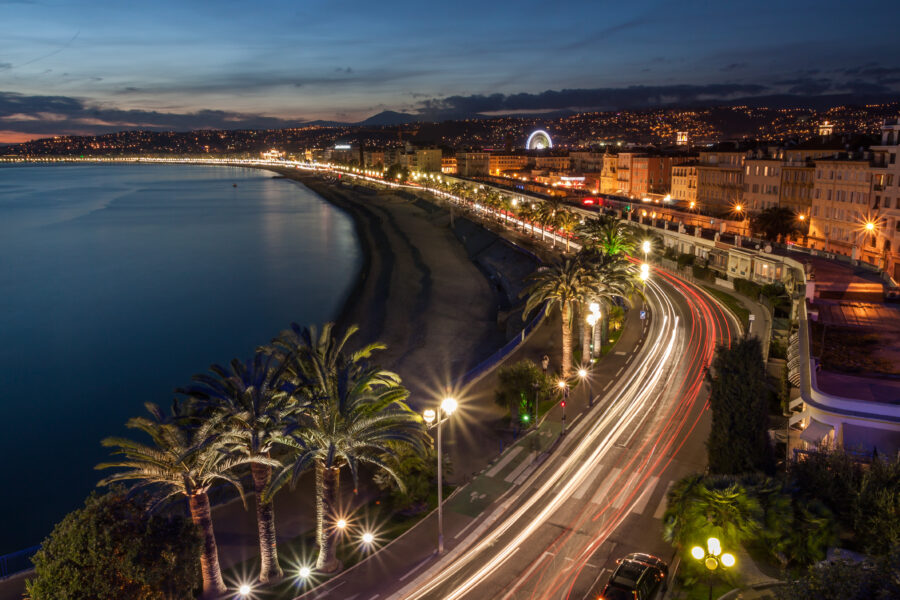 Nighttime cityscape of Nice, France, with illuminated buildings and a serene atmosphere along the French Riviera at dusk.