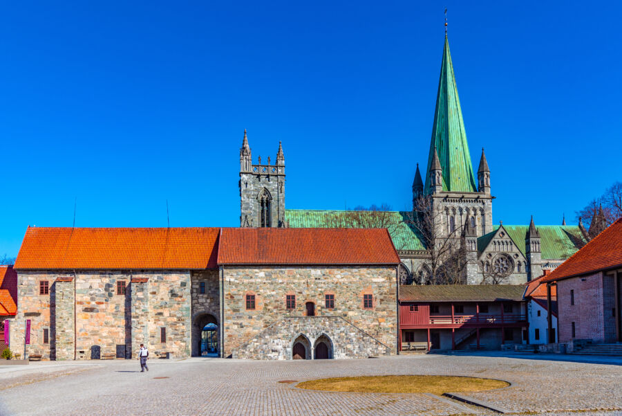 View of Nidaros Cathedral from the Archbishop's Palace courtyard in Trondheim, Norway, highlighting its grand Gothic design.
