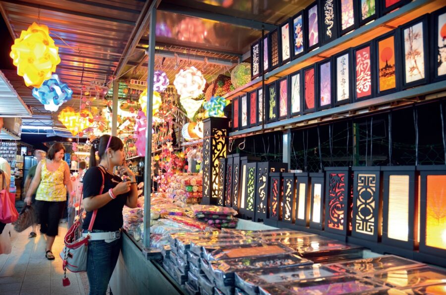 Colorful Batu Ferringhi night market lantern stall with glowing lamps, shoppers, and vibrant street bazaar atmosphere.