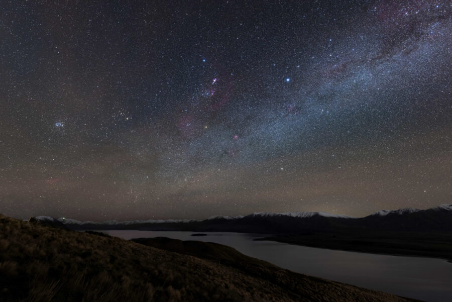 Milky Way night sky over mountain lake landscape in Aoraki Mackenzie Dark Sky Reserve.