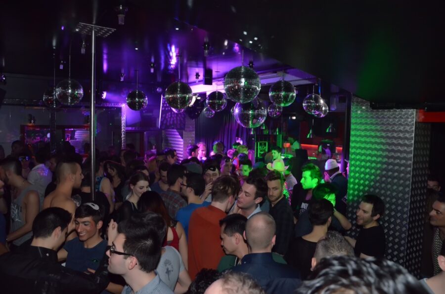 Dynamic nightclub scene with diverse crowd, vibrant lights, and lively energy.