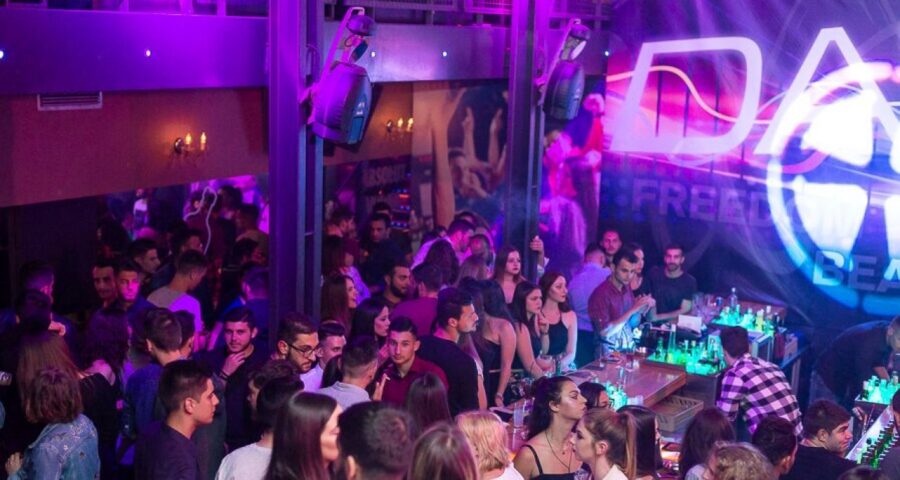 Bustling nightclub scene with diverse crowd enjoying vibrant music and lively atmosphere.
