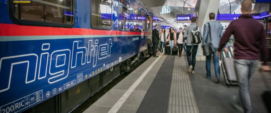 Nightjet night train at Vienna Central Station platform with passengers boarding.