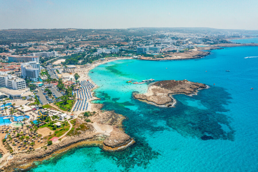 Nissi Beach in Cyprus features stunning white sands and clear turquoise waters, creating a tropical paradise atmosphere.