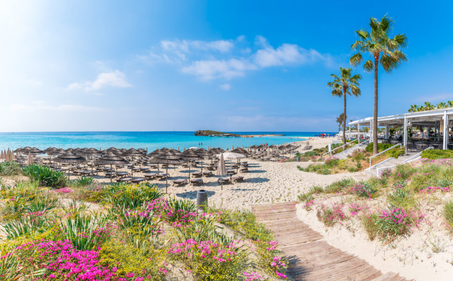 Nissi Beach in Cyprus features stunning white sands and clear turquoise waters, creating a tropical paradise atmosphere.