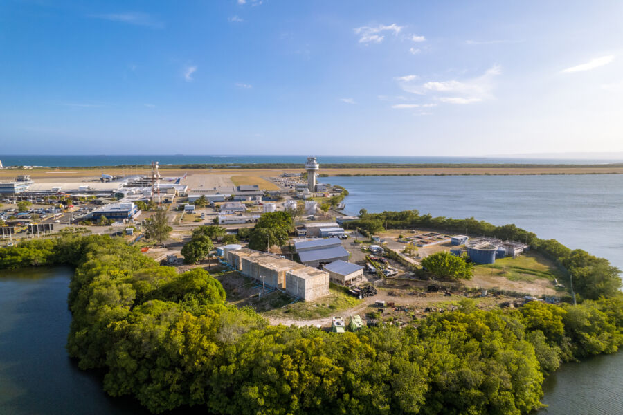Norman Manley International Airport in Jamaica, showcasing the control tower against a backdrop of the Caribbean sky