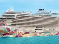 Vibrant Norwegian Aqua cruise ship with colorful hull against serene sea and blue sky.