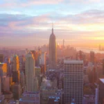 Aerial view of New York City skyline at twilight featuring the Empire State Building.
