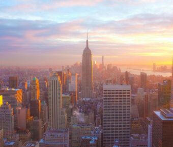 Aerial view of New York City skyline at twilight featuring the Empire State Building.