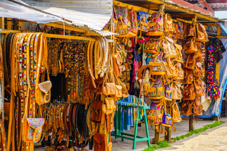 Indigenous leather handicrafts displayed at a market in Oaxaca, Mexico, showcasing intricate designs and vibrant colors