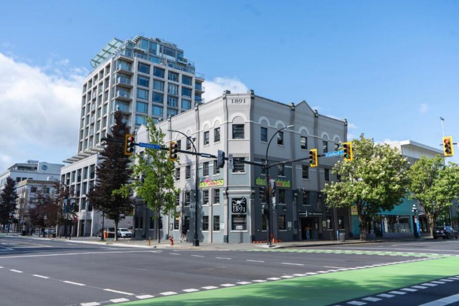 Street with a green traffic light and Ocean Island Inn building in the background, located in Victoria, Canada.