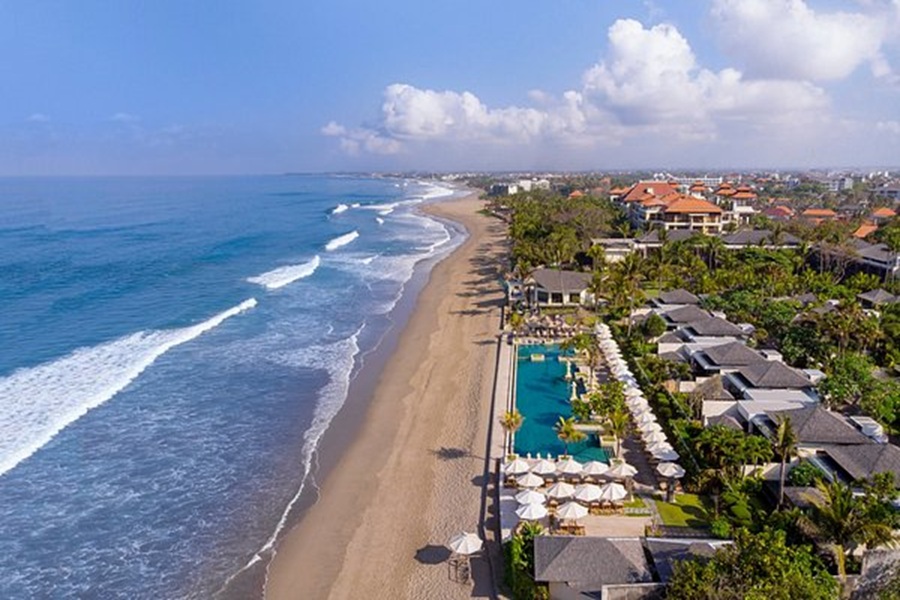 Luxury Seminyak beachfront resort with infinity pool, golden sand beach, and turquoise ocean views.