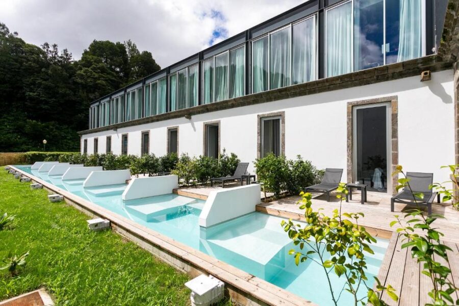 Spacious swimming pool nestled in a vibrant garden at Octant Furnas, Portugal, inviting relaxation and enjoyment.