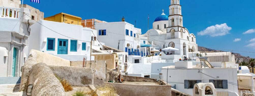 Santorini Airport building featuring a prominent white roof against a clear blue sky.