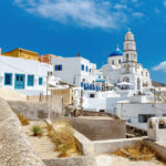 Santorini Airport building featuring a prominent white roof against a clear blue sky.