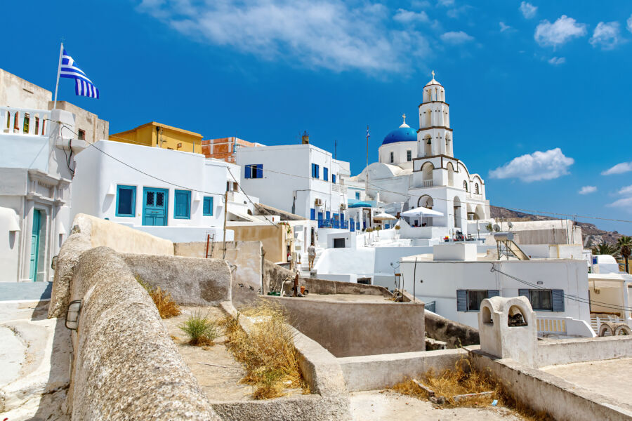 Santorini Airport building featuring a prominent white roof against a clear blue sky.