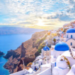 Scenic view of Oia, Santorini, showcasing traditional white architecture and blue-domed churches by the Aegean Sea