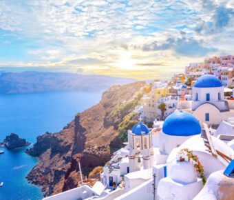 Scenic view of Oia, Santorini, showcasing traditional white architecture and blue-domed churches by the Aegean Sea