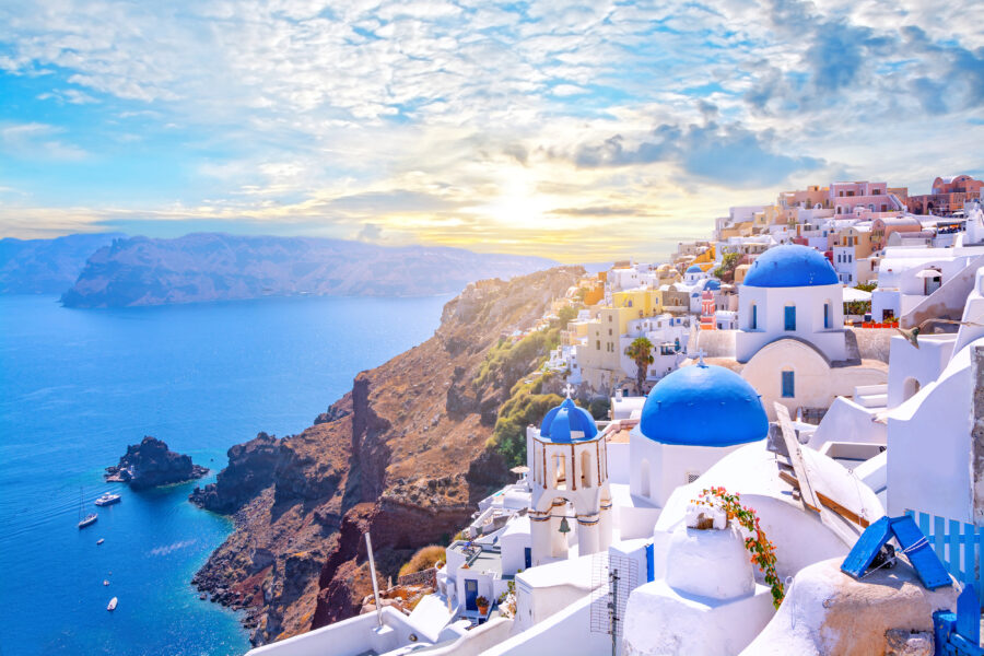 Scenic view of Oia, Santorini, showcasing traditional white architecture and blue-domed churches by the Aegean Sea