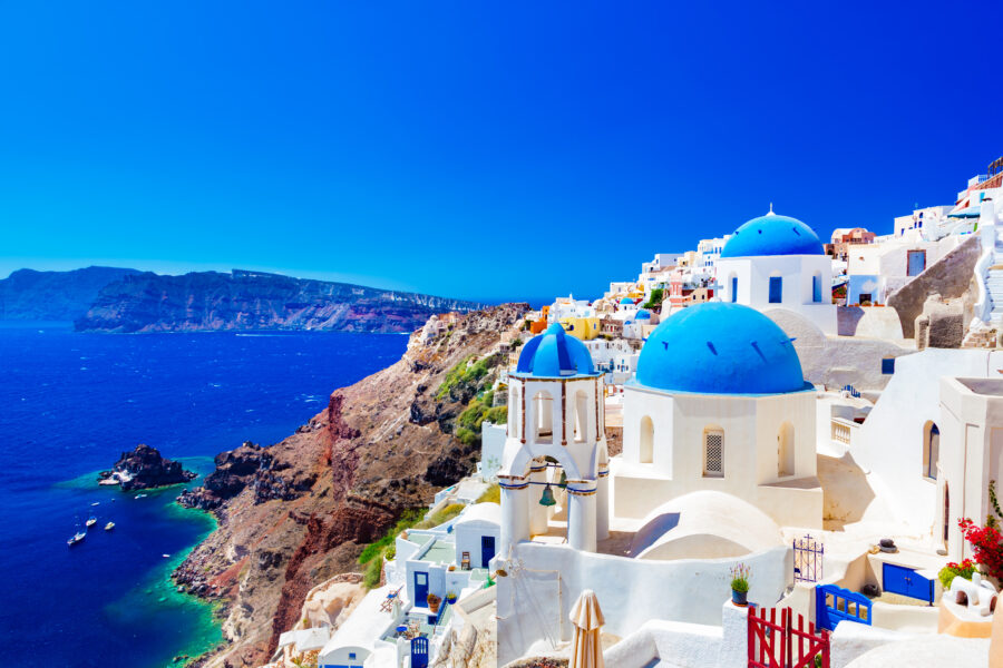 Scenic view of Oia, Santorini, with whitewashed buildings and the Aegean Sea caldera in the background