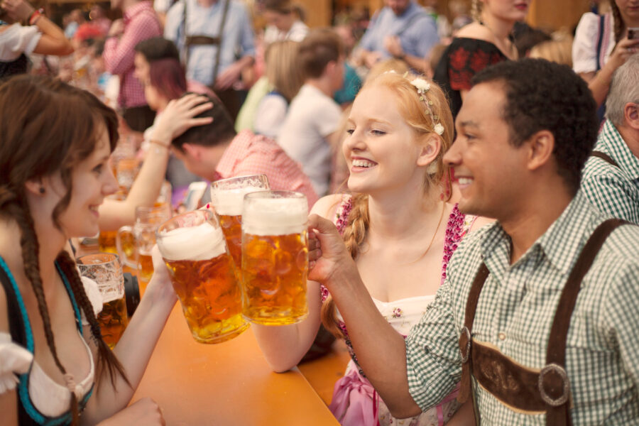 Friends celebrating Oktoberfest in Munich, holding drinks and enjoying the festive atmosphere together.