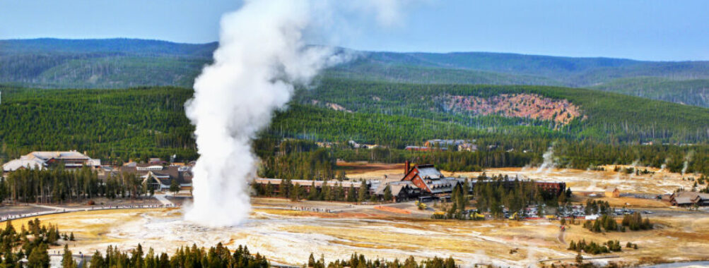 Old Faithful geyser erupting in Yellowstone National Park, Wyoming, showcasing the park's natural beauty and geothermal features.