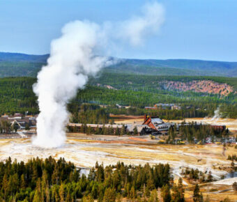 Old Faithful geyser erupting in Yellowstone National Park, Wyoming, showcasing the park's natural beauty and geothermal features.