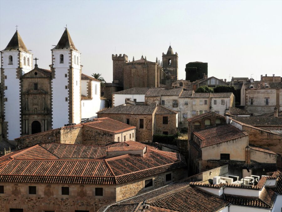 Charming Spanish town with historic architecture, church towers, and terracotta rooftops during golden hour.