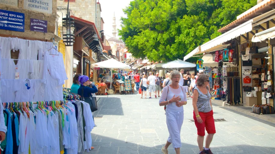 Rhodes Old Town market street with shops, cafes, tourists and minaret.