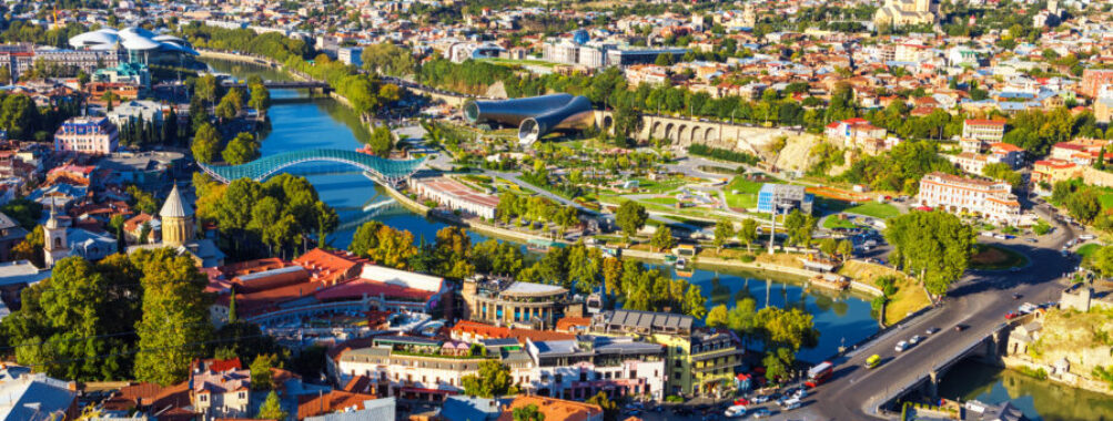 Aerial view from a funicular showing traditional wooden balconies of Old Town Tbilisi, Georgia, with houses below.