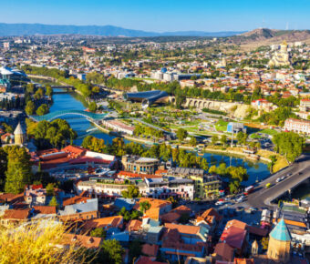 Aerial view from a funicular showing traditional wooden balconies of Old Town Tbilisi, Georgia, with houses below.