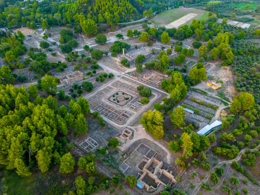 Scenic sunset view over the Archaeological Site of Olympia in Greece, highlighting its historic structures and landscape.
