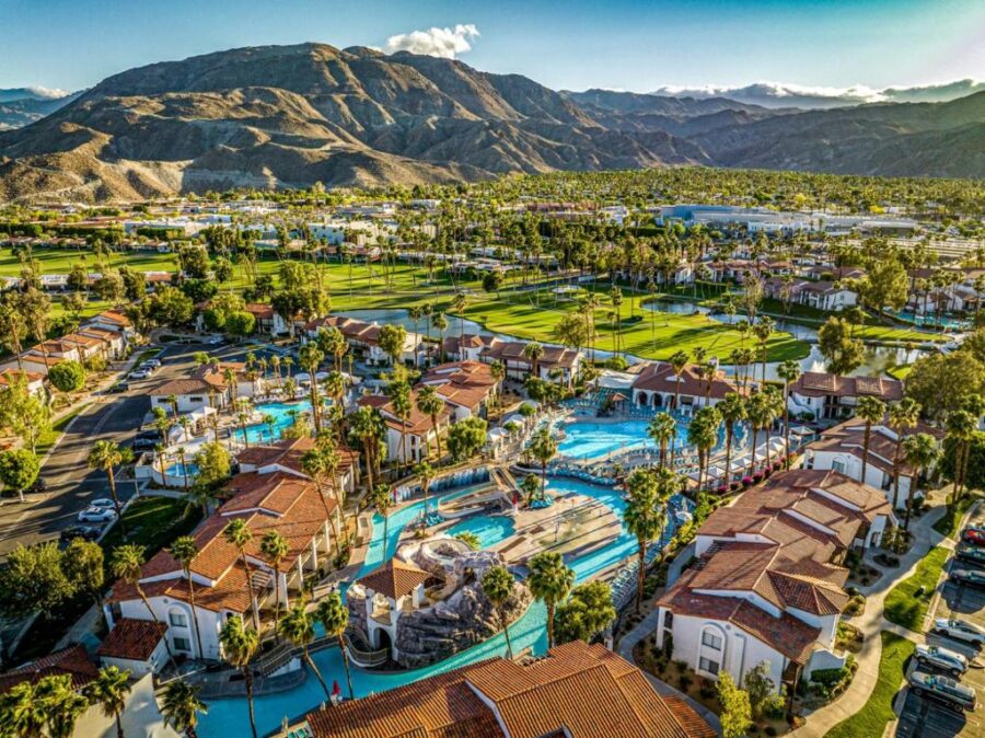 Aerial view of Omni Rancho Las Palmas Resort & Spa, showcasing its pools, palm trees, and surrounding desert landscape.
