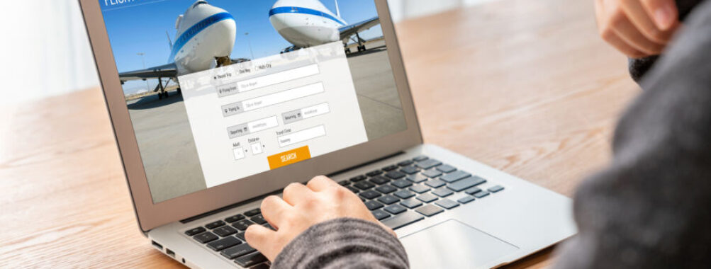 Modern flight booking interface on laptop, businessman browsing for travel, technology in travel booking.