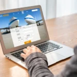 Modern flight booking interface on laptop, businessman browsing for travel, technology in travel booking.