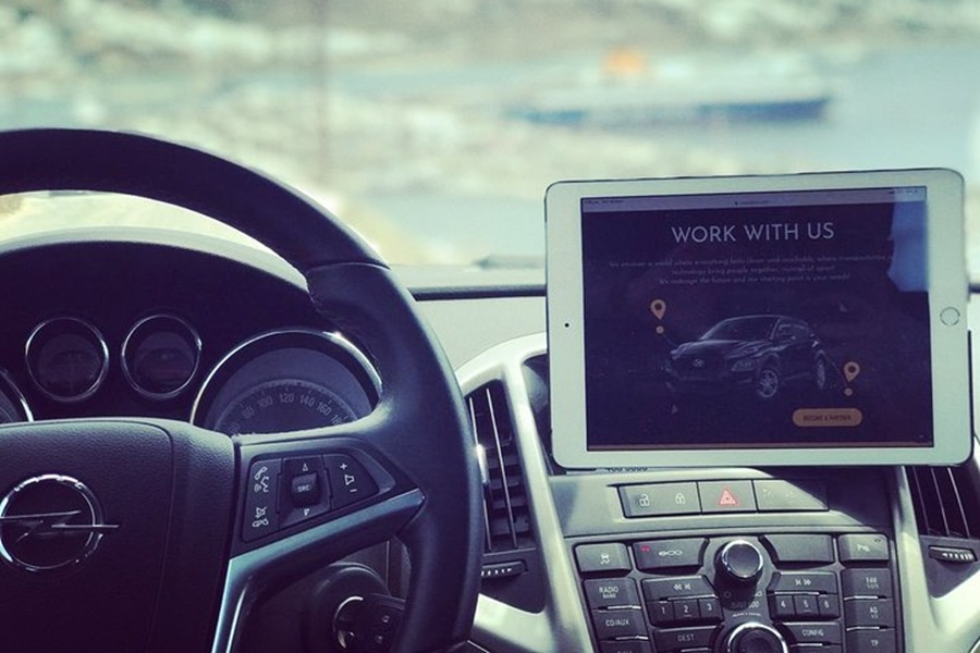 Modern car interior with digital tech and scenic coastal backdrop.