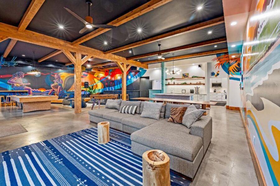 Modern open-concept room with artistic murals, industrial décor, and entertainment space.